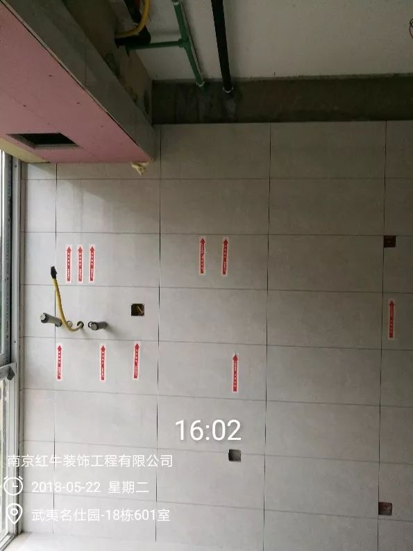 南京武夷名仕園124平米簡(jiǎn)美風(fēng)格裝修  享受家?guī)?lái)的溫度30五月份_墻磚鋪貼完成后，紅牛裝飾的工人會(huì)用專用護(hù)角條對(duì)瓷磚角保護(hù)，用標(biāo)貼標(biāo)出水管、線管走向示意。